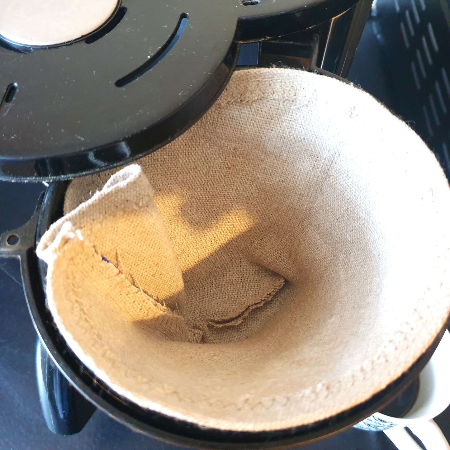 Återanvändbart kaffefilter i linne, storlek 4, placerat i en kaffebryggare. Ett miljövänligt alternativ till engångsfilter, designat för att minska avfall och skapa en mer hållbar kaffevana.